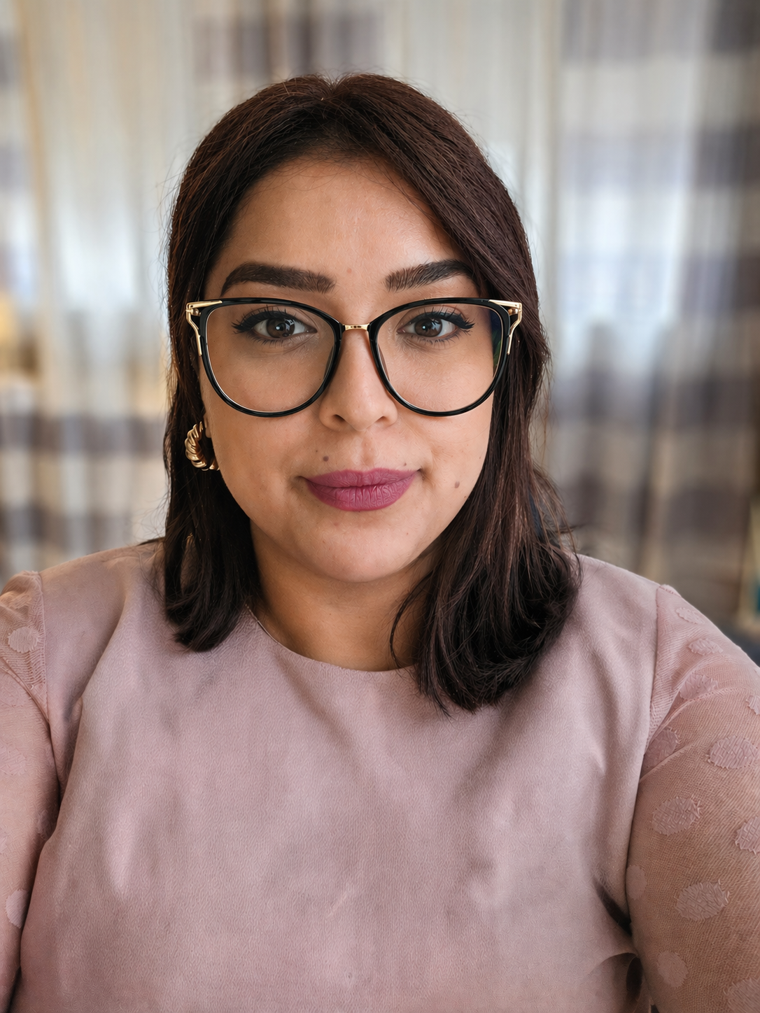 Dr. Bhatoa, naturopathic doctor, smiling in glasses and a soft pink top