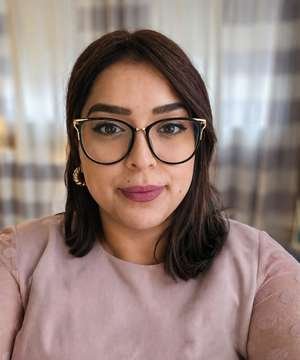 Dr. Bhatoa, naturopathic doctor, smiling in glasses and a soft pink top